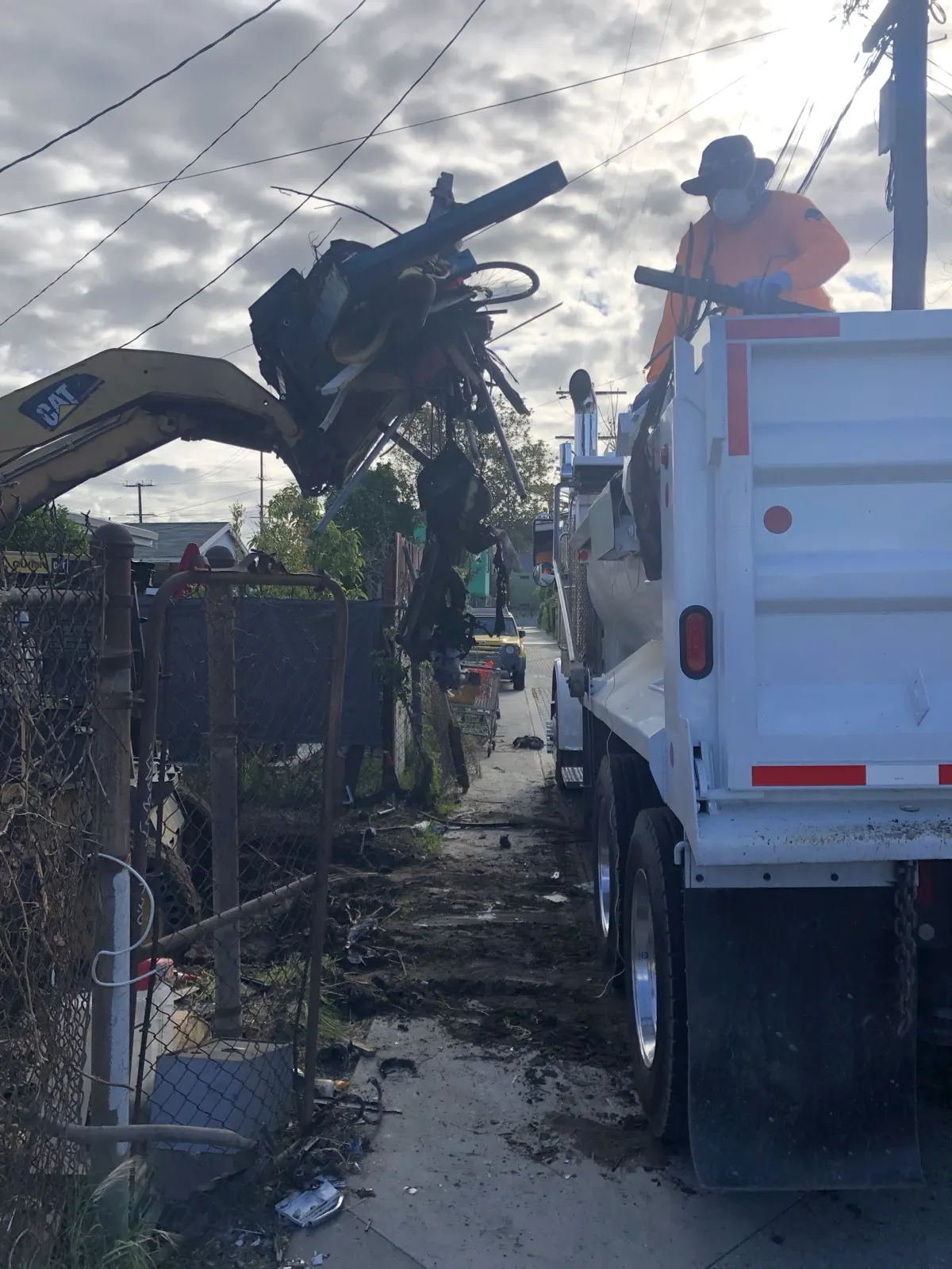 Loading demolition debris into one of our dump trucks from a narrow alley