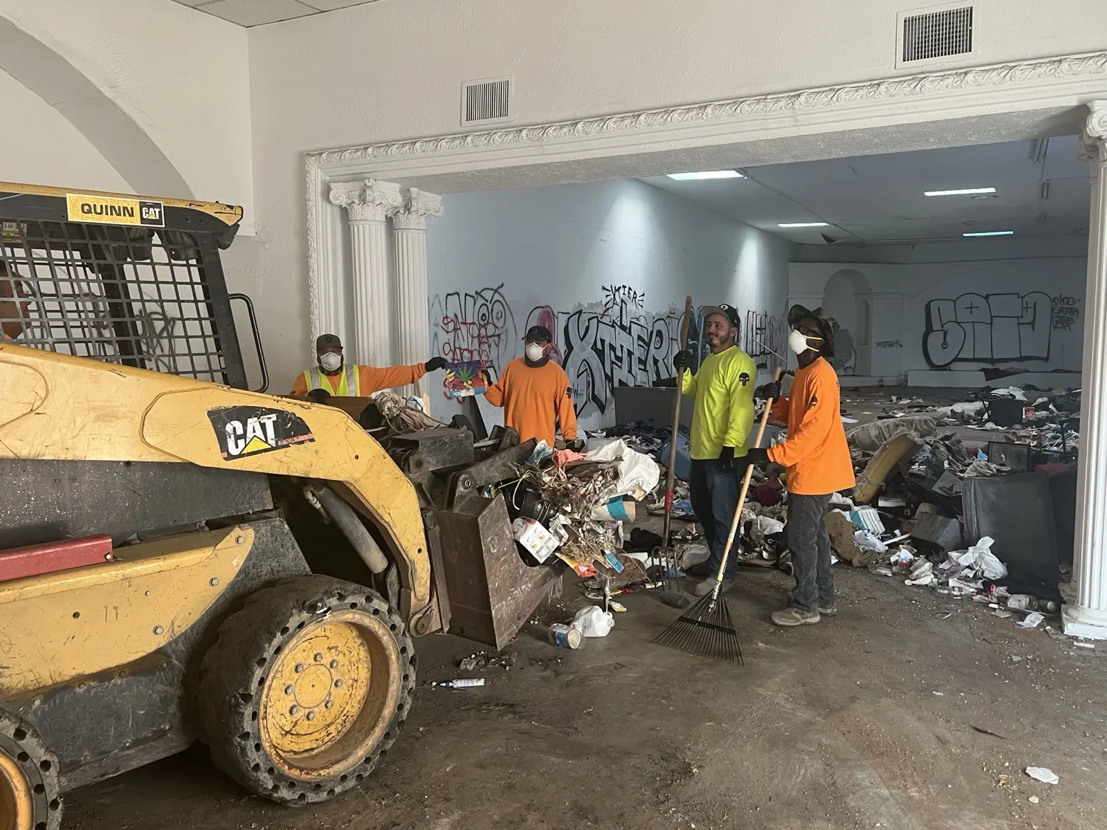 Our crew and a skid steer clearing debris piles out of an emptied interior