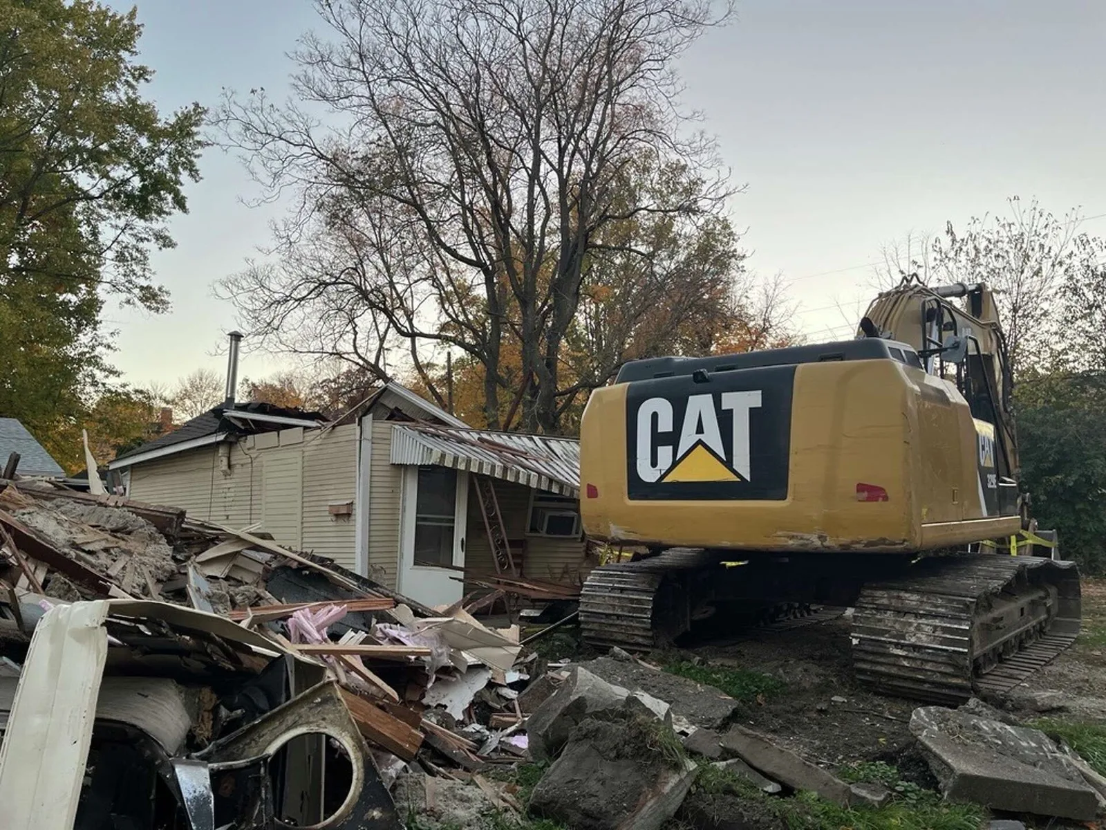 Excavator taking down a house during residential demolition