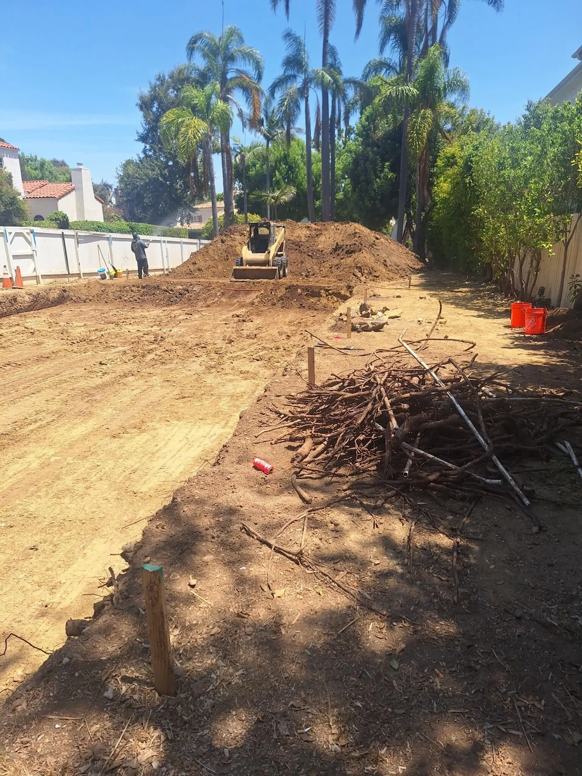Southwest Hauling skid steer clearing brush and roots during a lot cleanup
