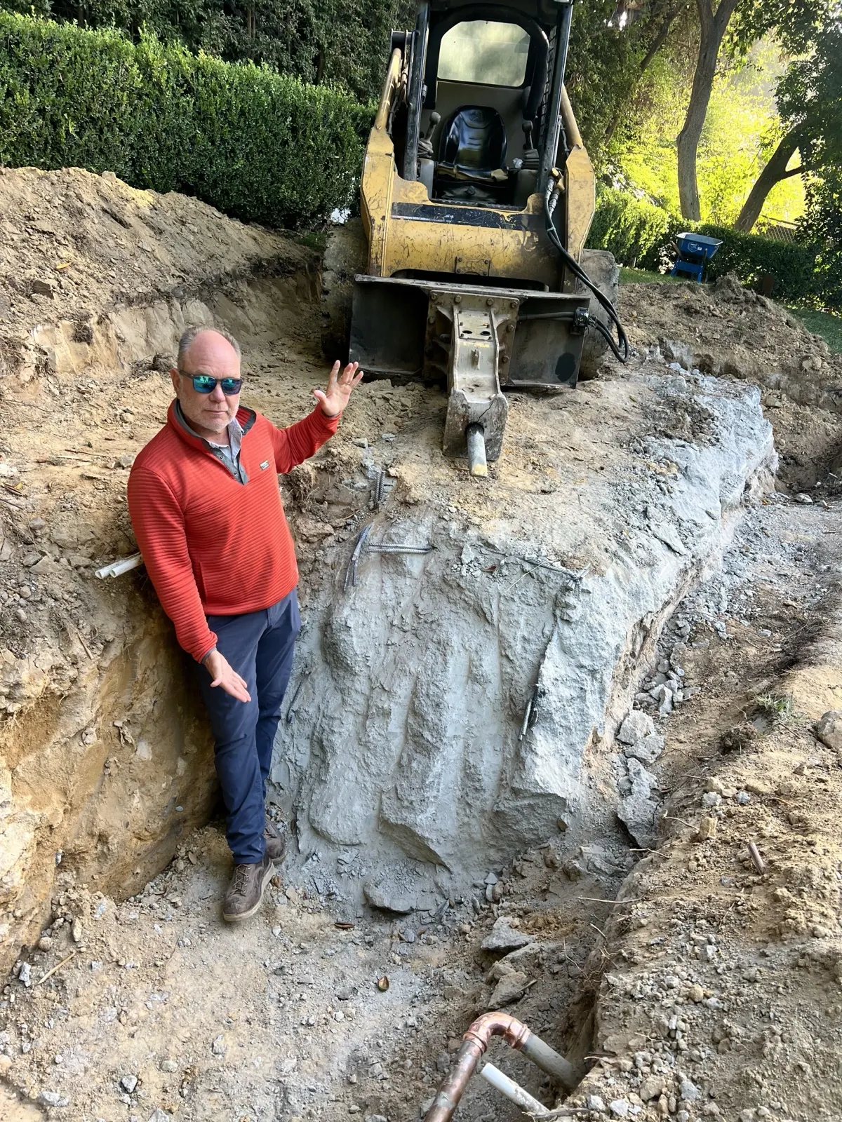 Deep trench our crew cut through rock with a skid steer and breaker